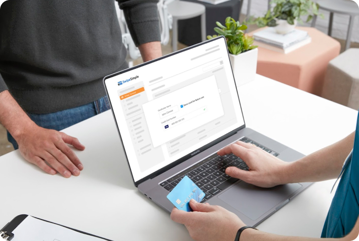 Small business owner typing credit card information into their laptop computer using SwipeSimple 