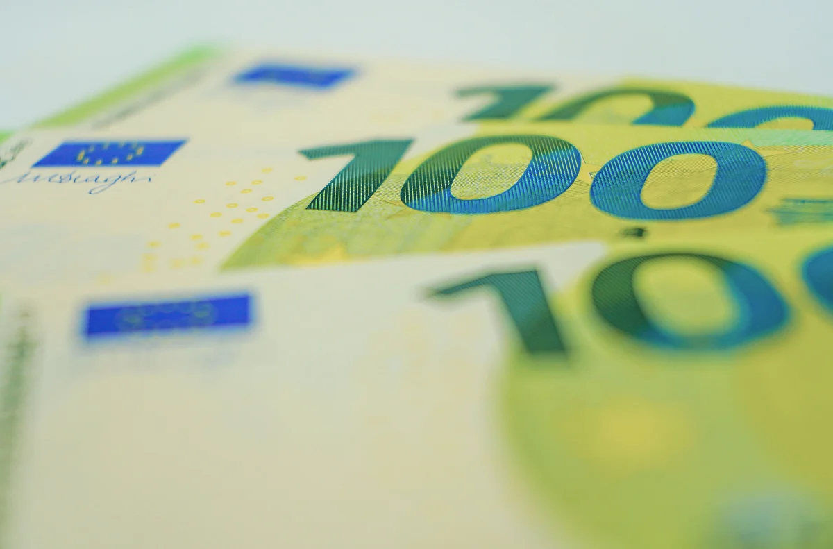 Extreme close-up of overlapping 100 Euro banknotes with a shallow depth of field.