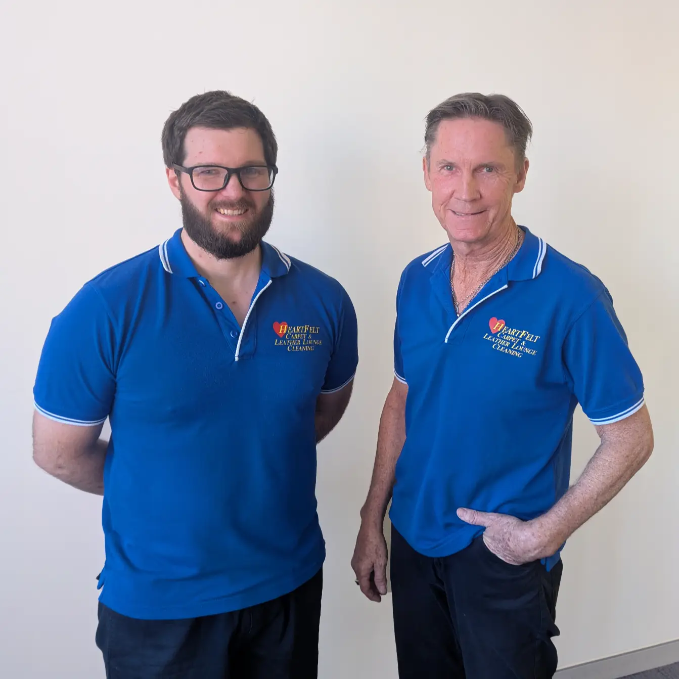 A photo of two workers wearing blue Heartfelt Carpet Cleaning shirts.