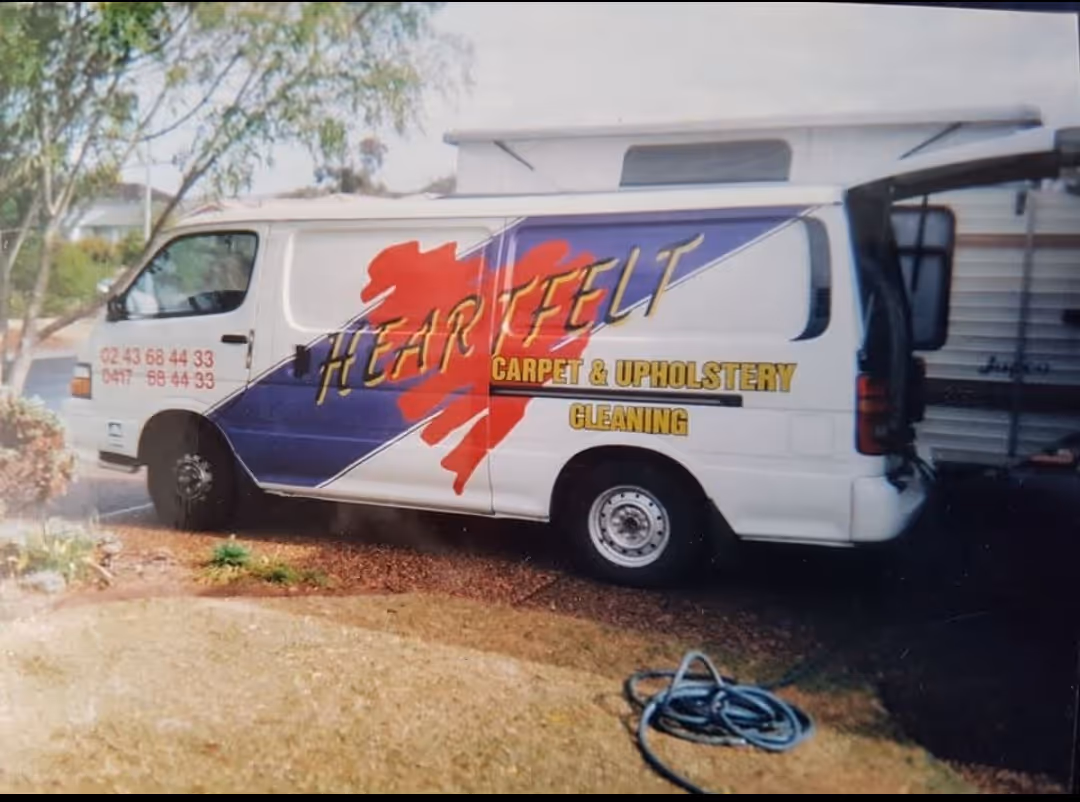 Heartfelt Cleaning’s original white service van with company logo and graphics parked outdoors.