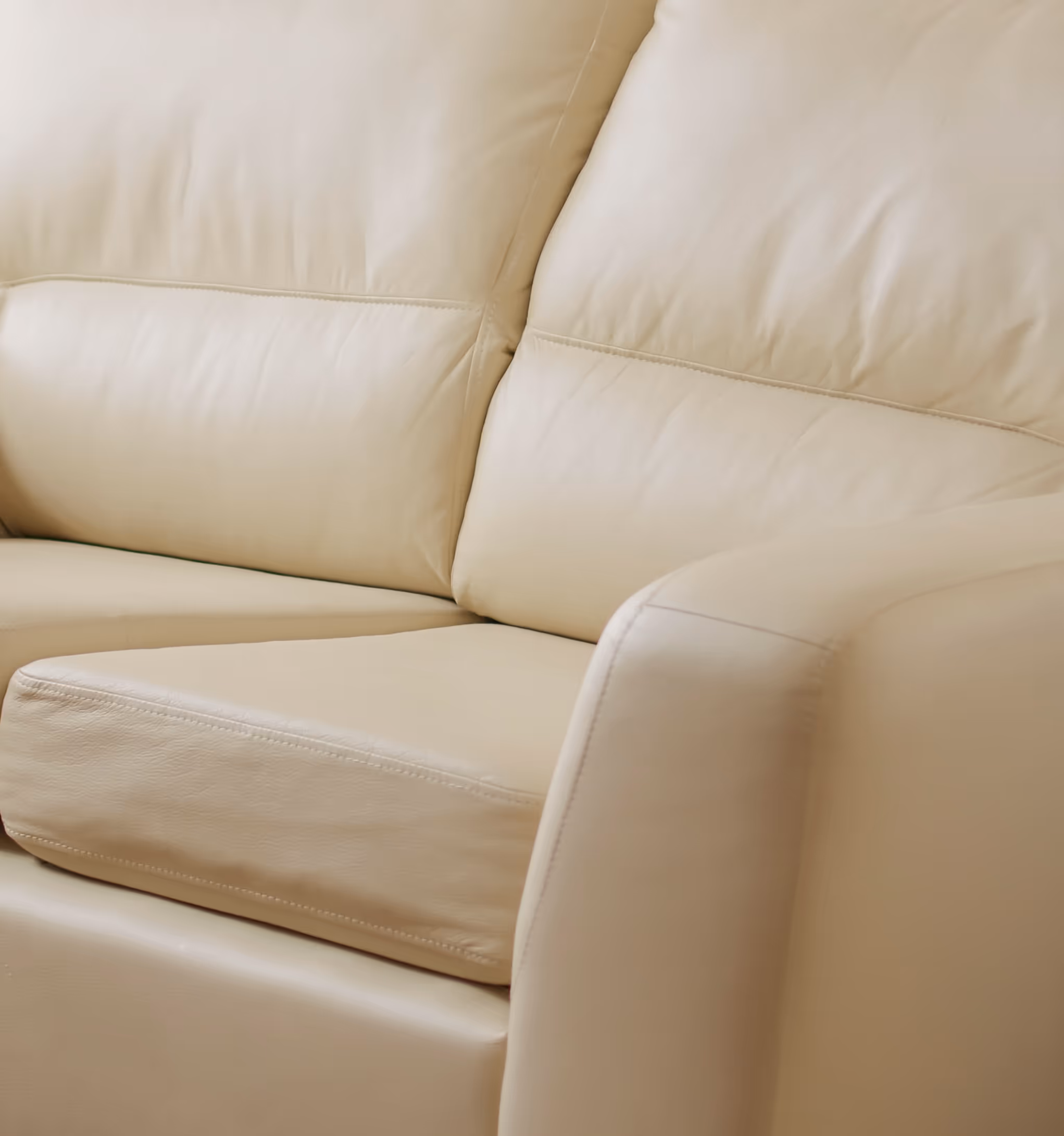 Close-up of a white leather lounge with smooth cushions.