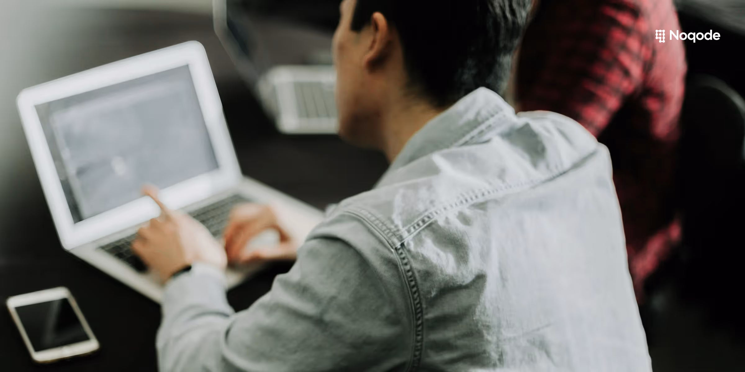 Personne travaillant sur ordinateur portable pour préparer le brief de son site vitrine avec logo Noqode