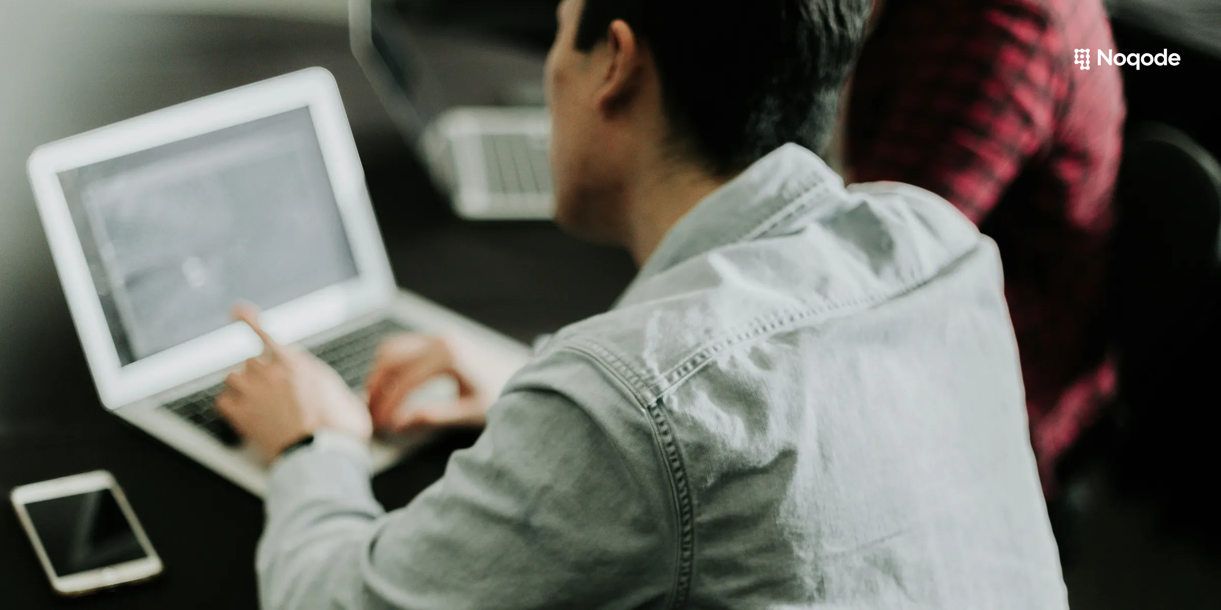 Personne travaillant sur ordinateur portable pour préparer le brief de son site vitrine avec logo Noqode
