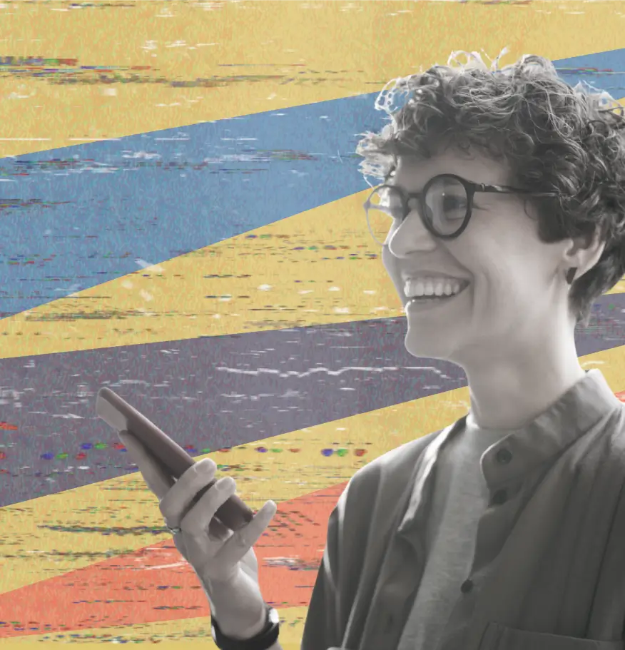 Smiling person with short curly hair and glasses holding a smartphone, standing in front of an abstract background with diagonal stripes in yellow, blue, purple, and orange.