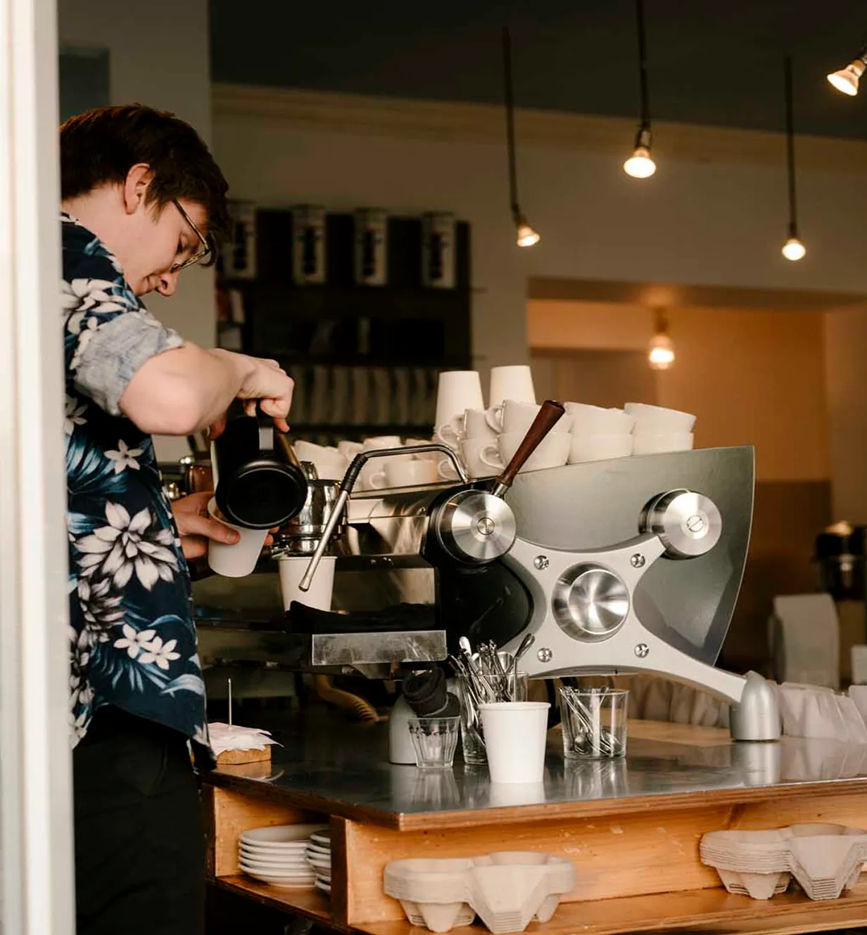 a guy pouring coffee in a coffee shop