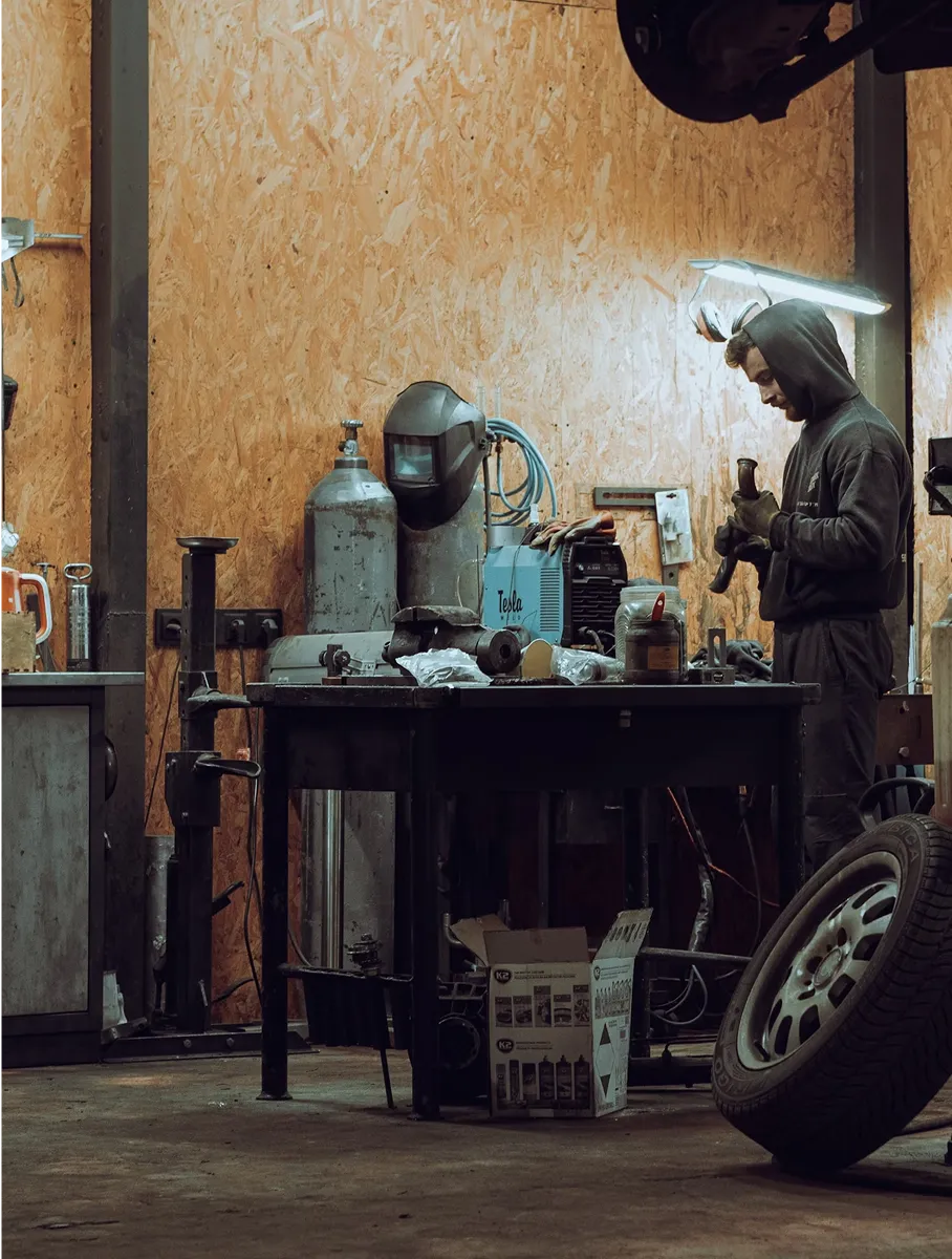 a man in a black hoodie working in a tire shop