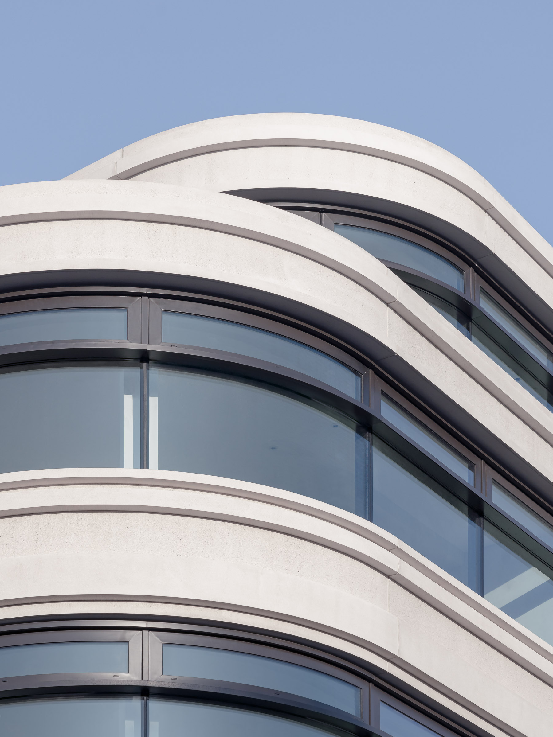 Tyen Masten Studio - One Putney. Corner detail showing the curved facade geometry and reflective glazing system.