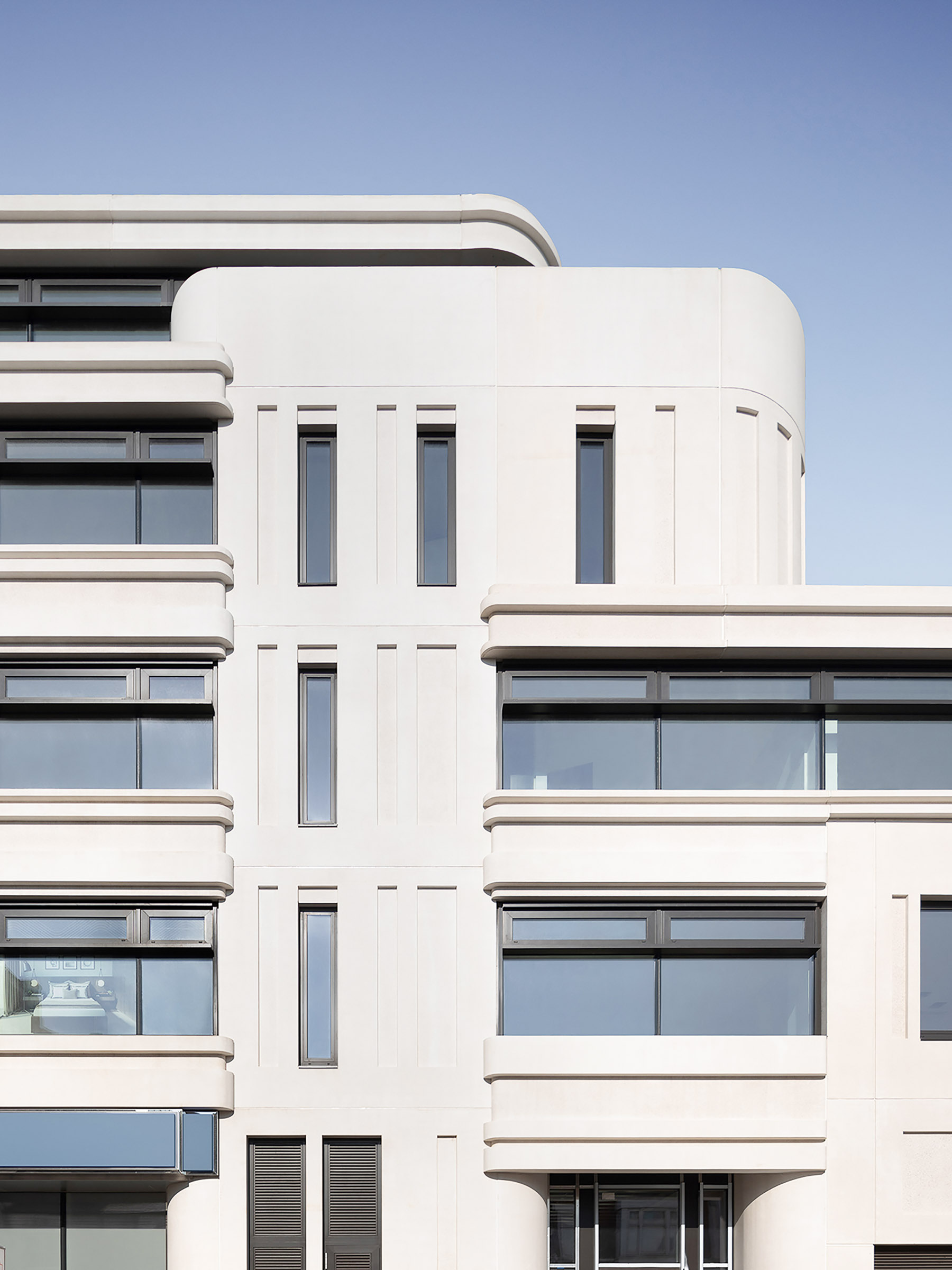 Building elevation expressing the formal rhythm of curved and linear facade elements across multiple floors.