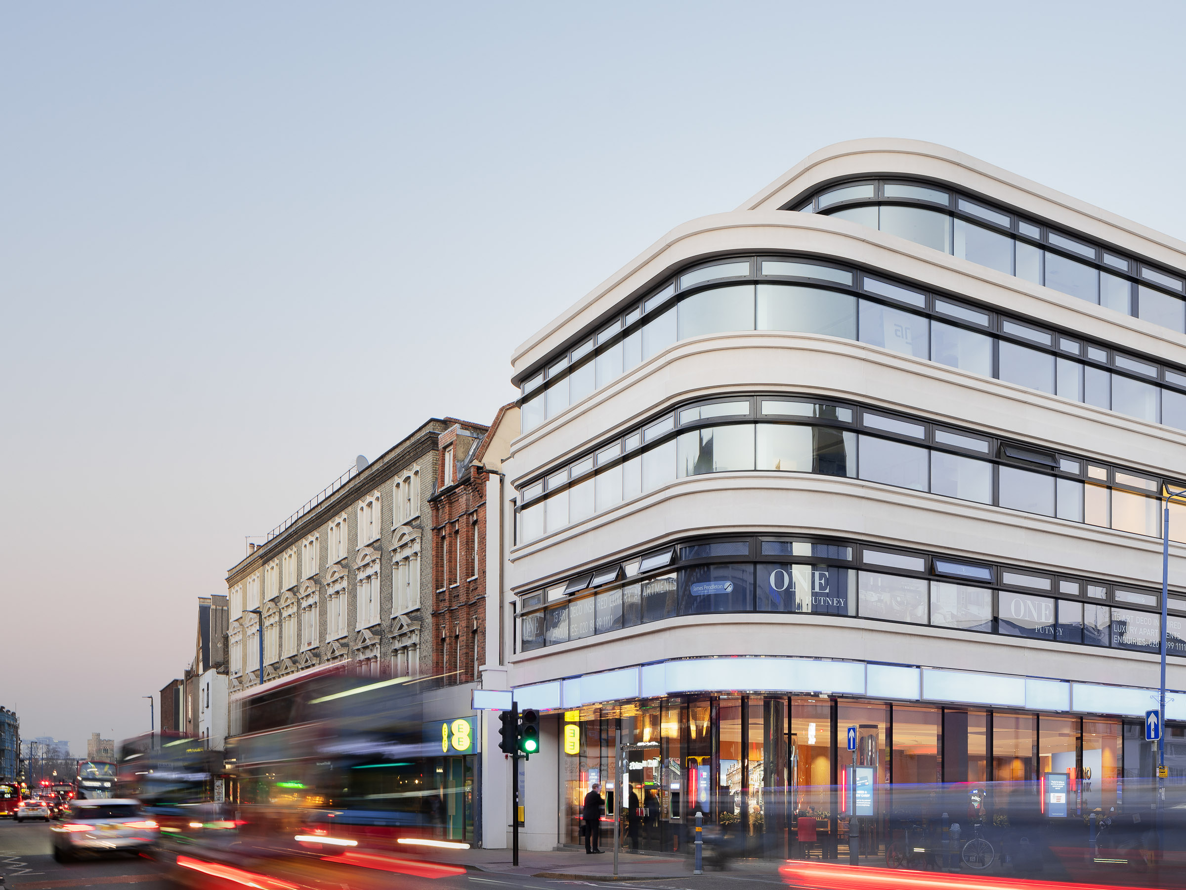 Wide street-level perspective capturing the urban presence and retail frontage of the corner building.