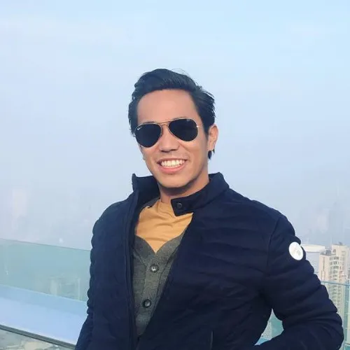 Man wearing sunglasses and black jacket smiling on urban rooftop