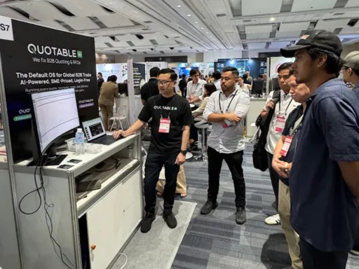 Conference attendees gather at Quotable booth displaying AI-powered app technology during expo event.