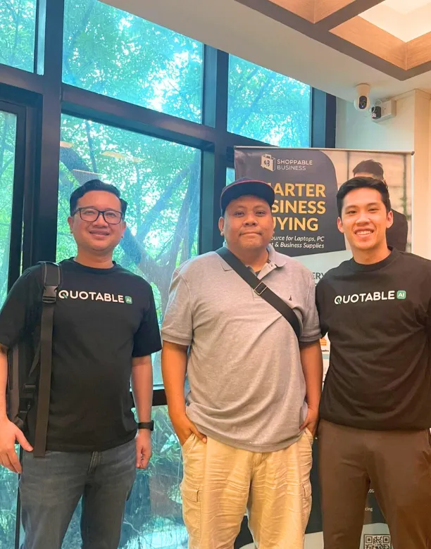 Quotable AI co-founders and Seedstars investor posing in front of large windows and Quotable AI business signage