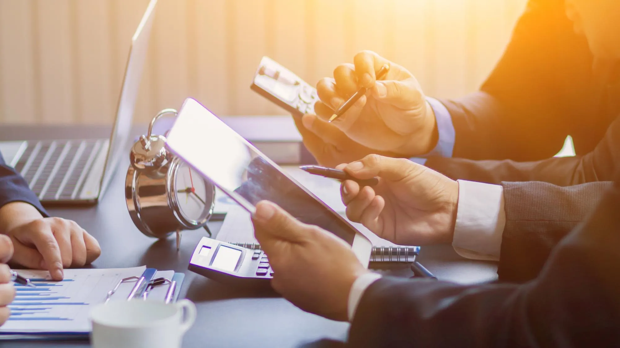 Business professionals discussing financial documents and data analysis at office desk.
