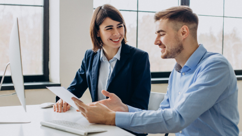 Two finance colleagues comparing B2B payment software options on a tablet.