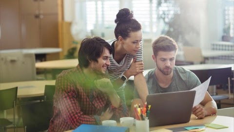 Small team reviewing a quoting workflow together on a laptop.