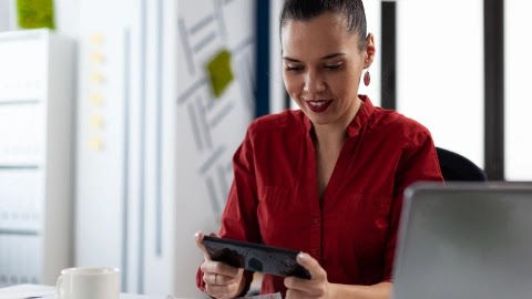Sales operations specialist reviewing a quote on a tablet at her desk.