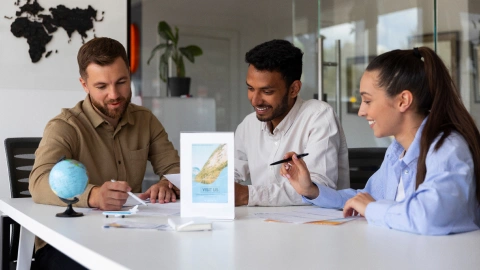 Team discusses international payment plans at a desk with a globe and world map.