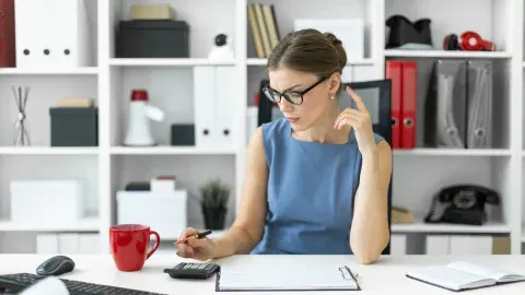 Businesswoman using a calculator at her desk.