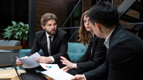 Concerned team discusses financial documents in an evening meeting