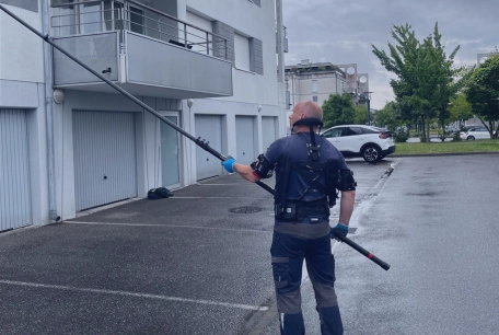 Exosquelette - professionnel équipé d'un dispositif sur du nettoyage de façade