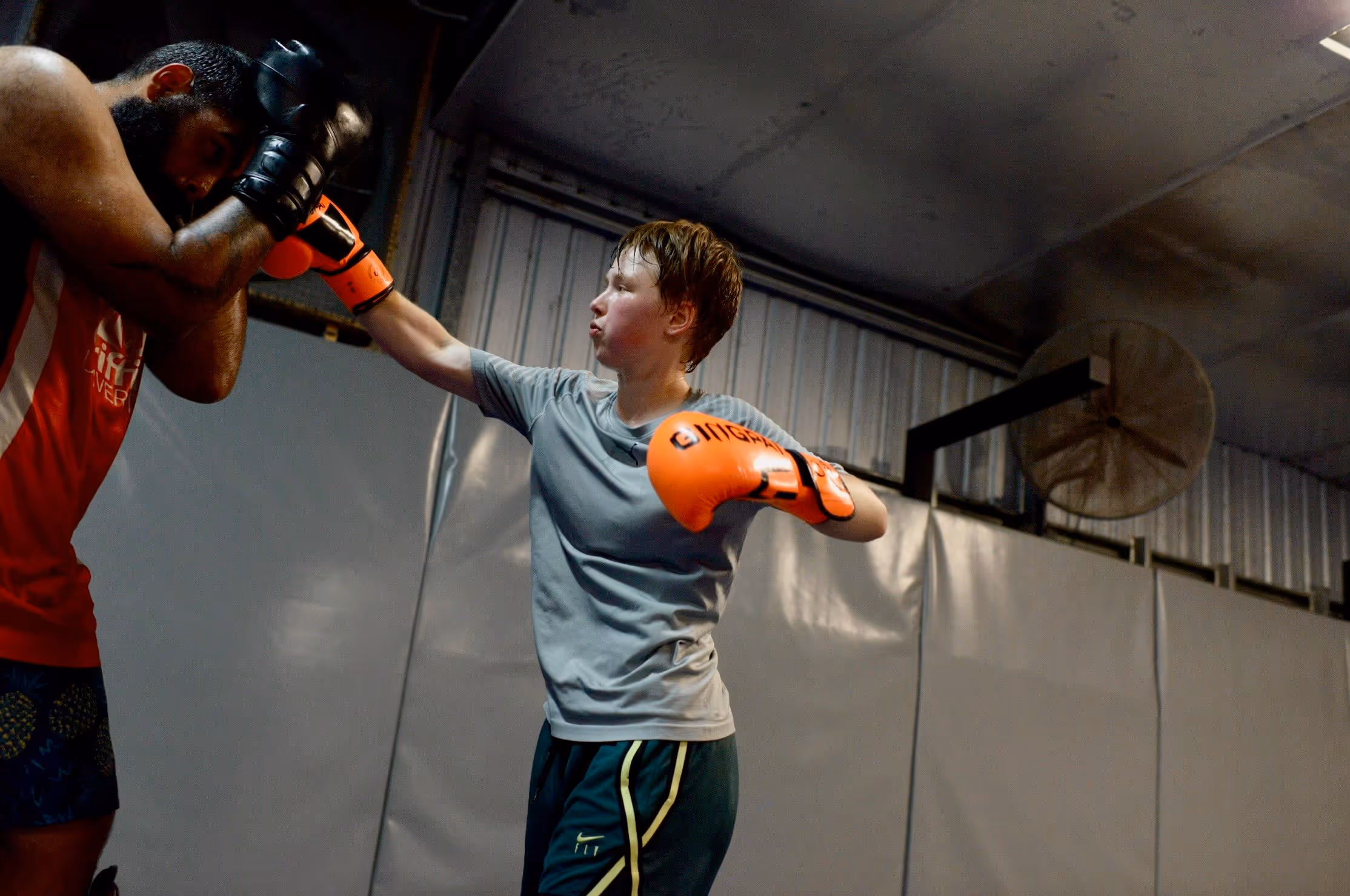 mixed martial arts kid punching pads