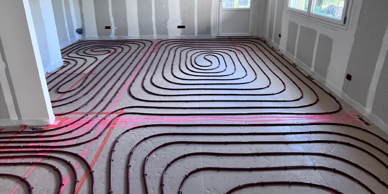 Boucles de plancher chauffant en tube PER posées sur isolant avant la chape, chantier à La Laupie
