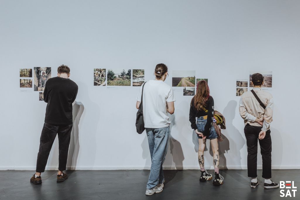 Наведнікі разглядаюць здымкі падчас адкрыцця выставы