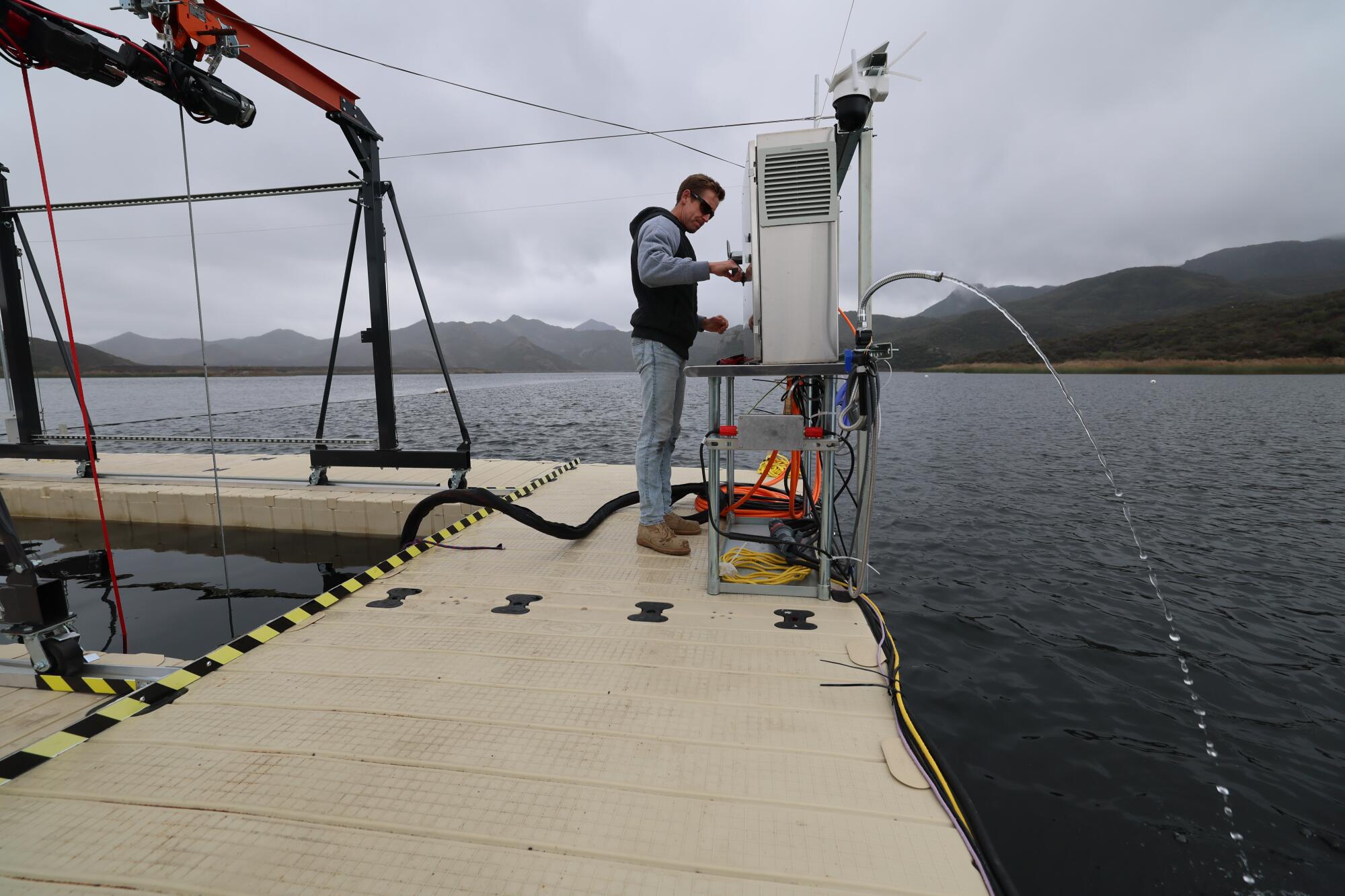 Mark Golay monitors filtered water coming from a pump as OceanWell tests a prototype of its desalination pod.