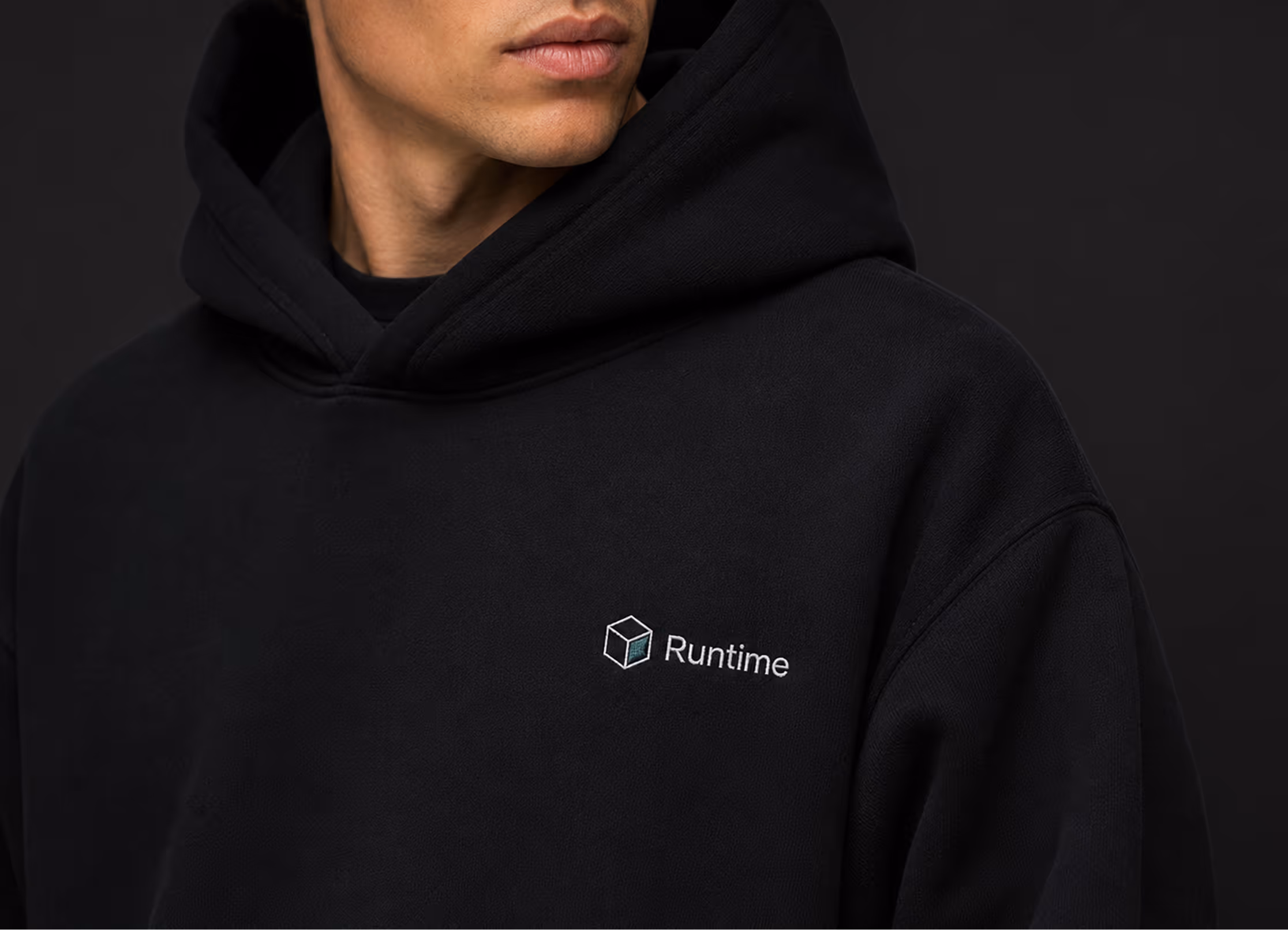 Person wearing a black hoodie with Runtime logo embroidered on the chest.