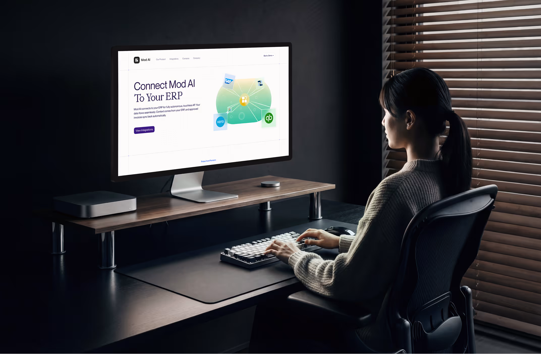 Person sitting at a desk using a computer displaying Mod AI ERP integration webpage.