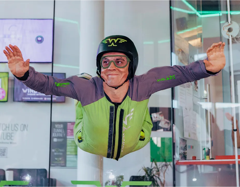 Man flying in wind tunnel smiling