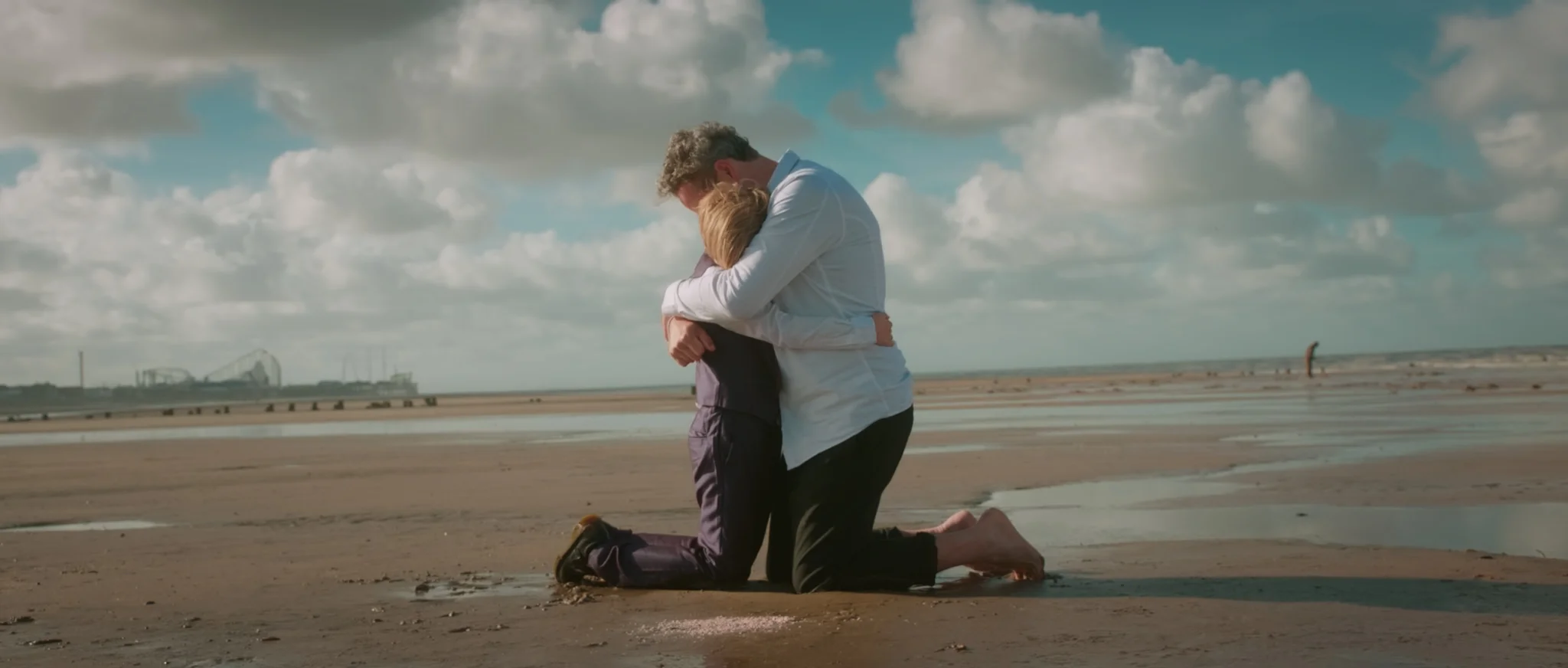 Still from the short drama 'Candy Floss' showing a father and child embracing on the beach