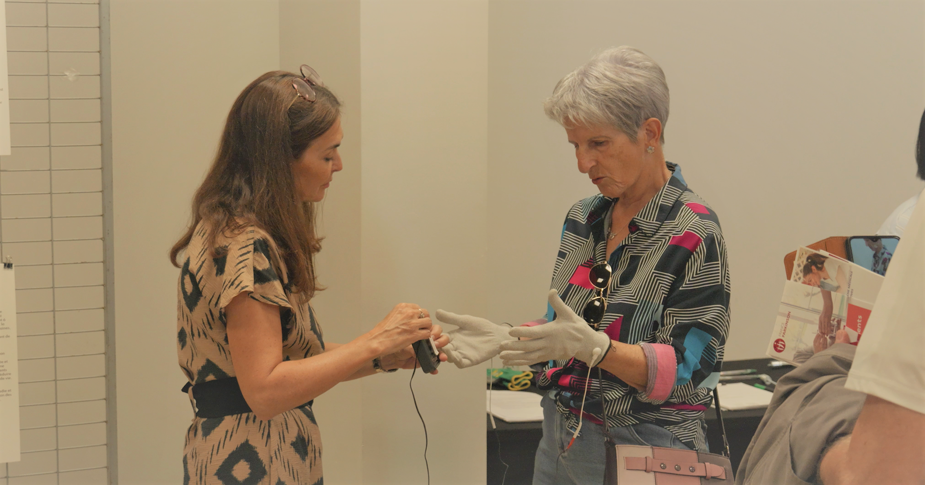 Deux femmes échangent lors d’un atelier de démonstration de gants connectés, dans le cadre d’un projet sur la maladie de Parkinson.
