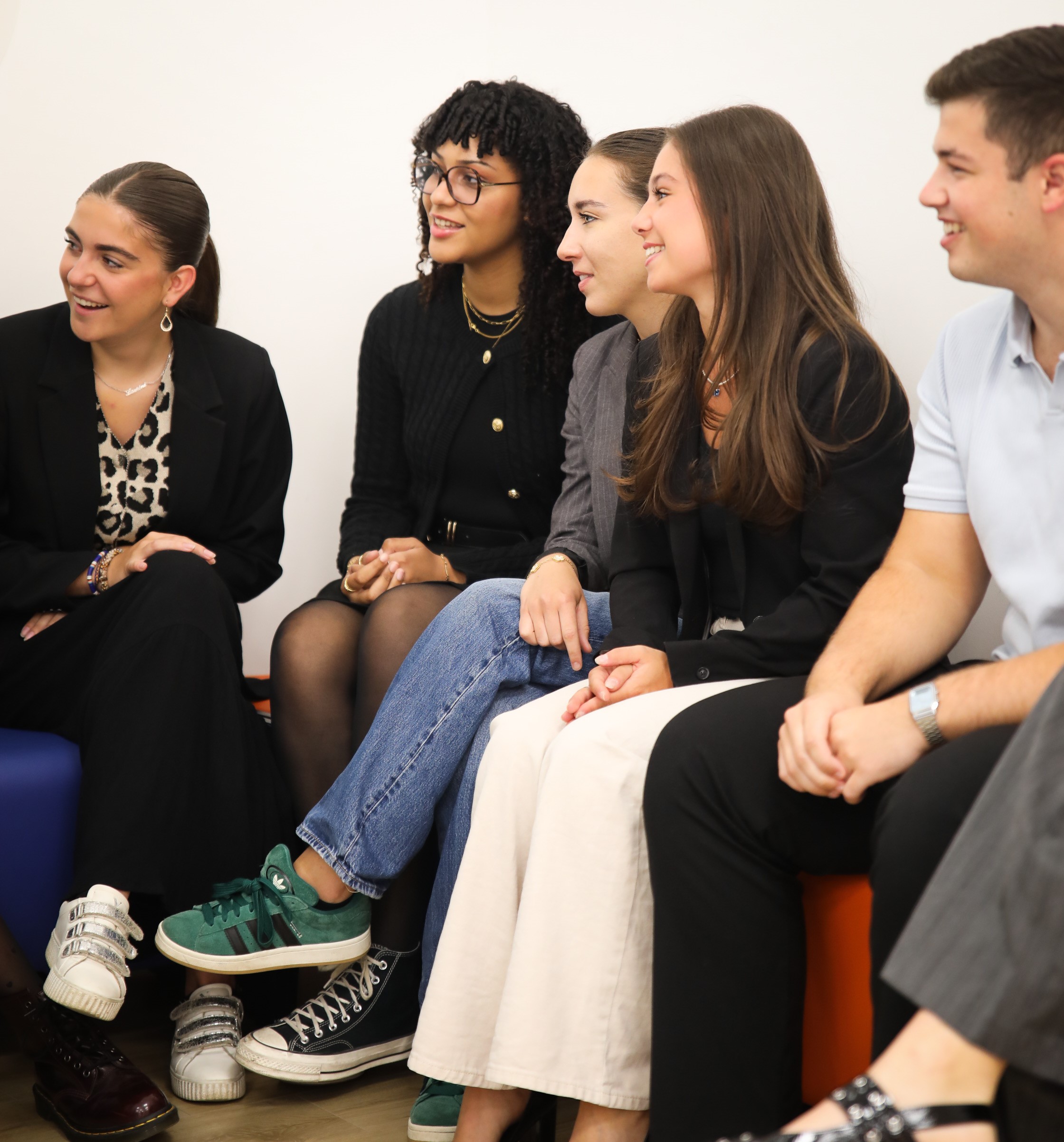 groupe d'étudiants assis sur un banc d'un air joyeux