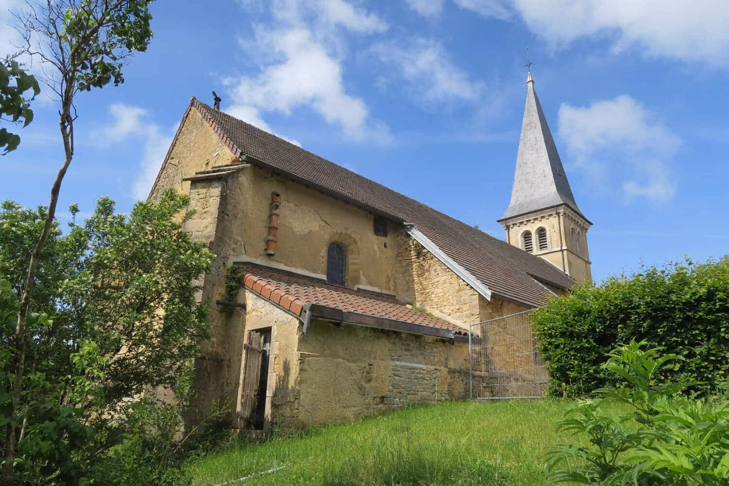 Eglise Sait-Etienne de Châtel de Gizia dans de la verdure avec un ciel bleu en arrière-plan
