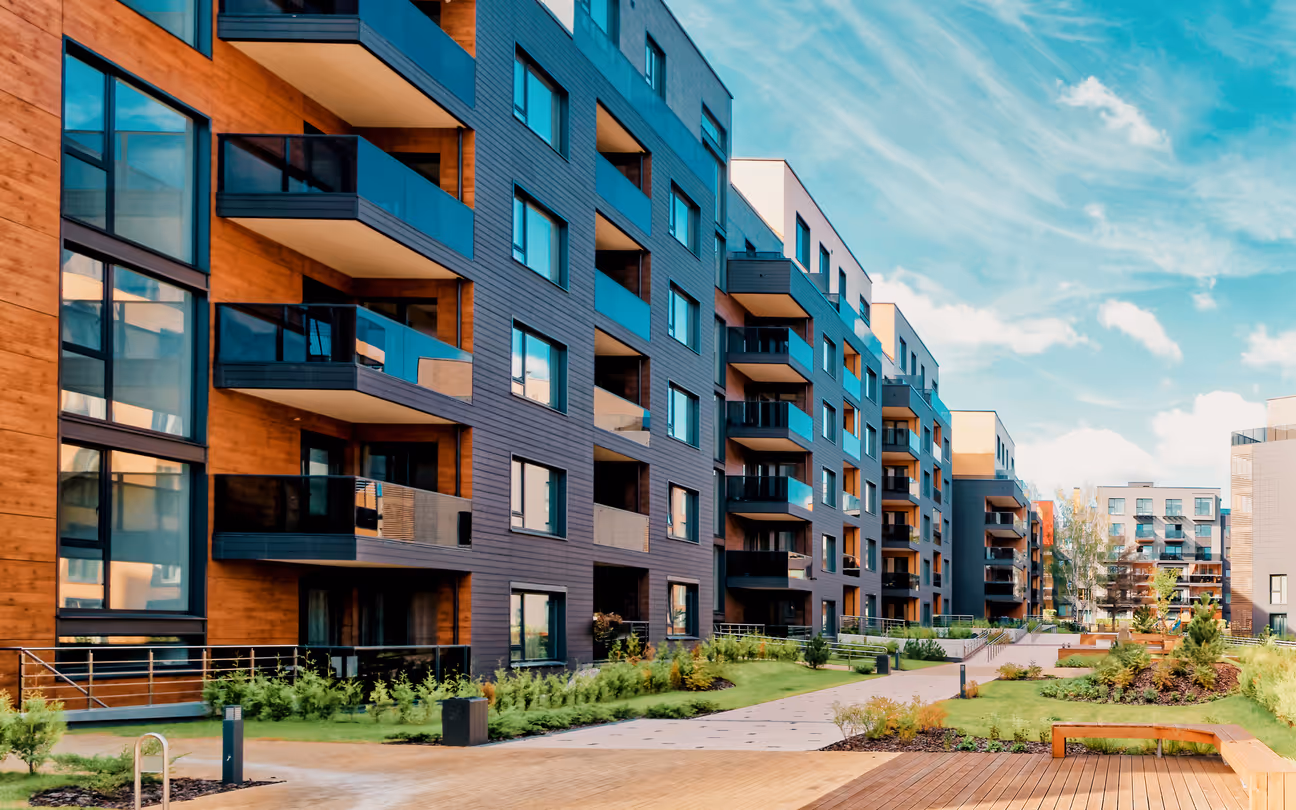 Modern apartment complex with colorful balconies and landscaped walkway