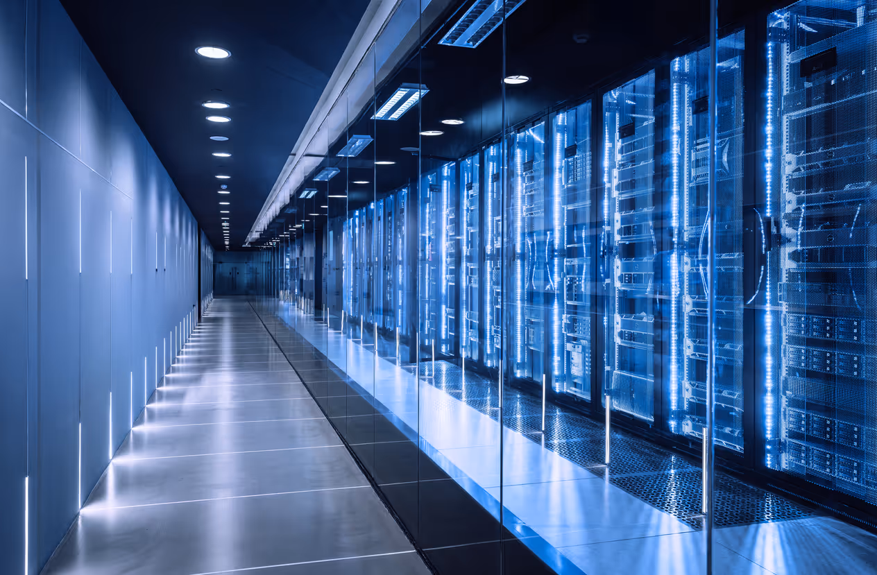 Modern data center with blue-lit server racks in long corridor