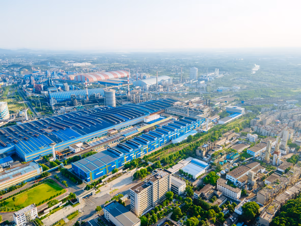 Aerial view of large industrial complex with blue buildings and factories