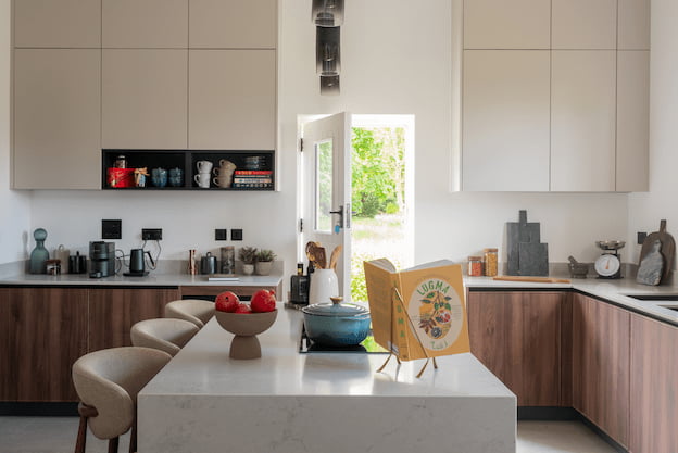 Kitchen with a white marble island, walnut cabinetry, wooden bar stools, and a stable door open to the garden.
