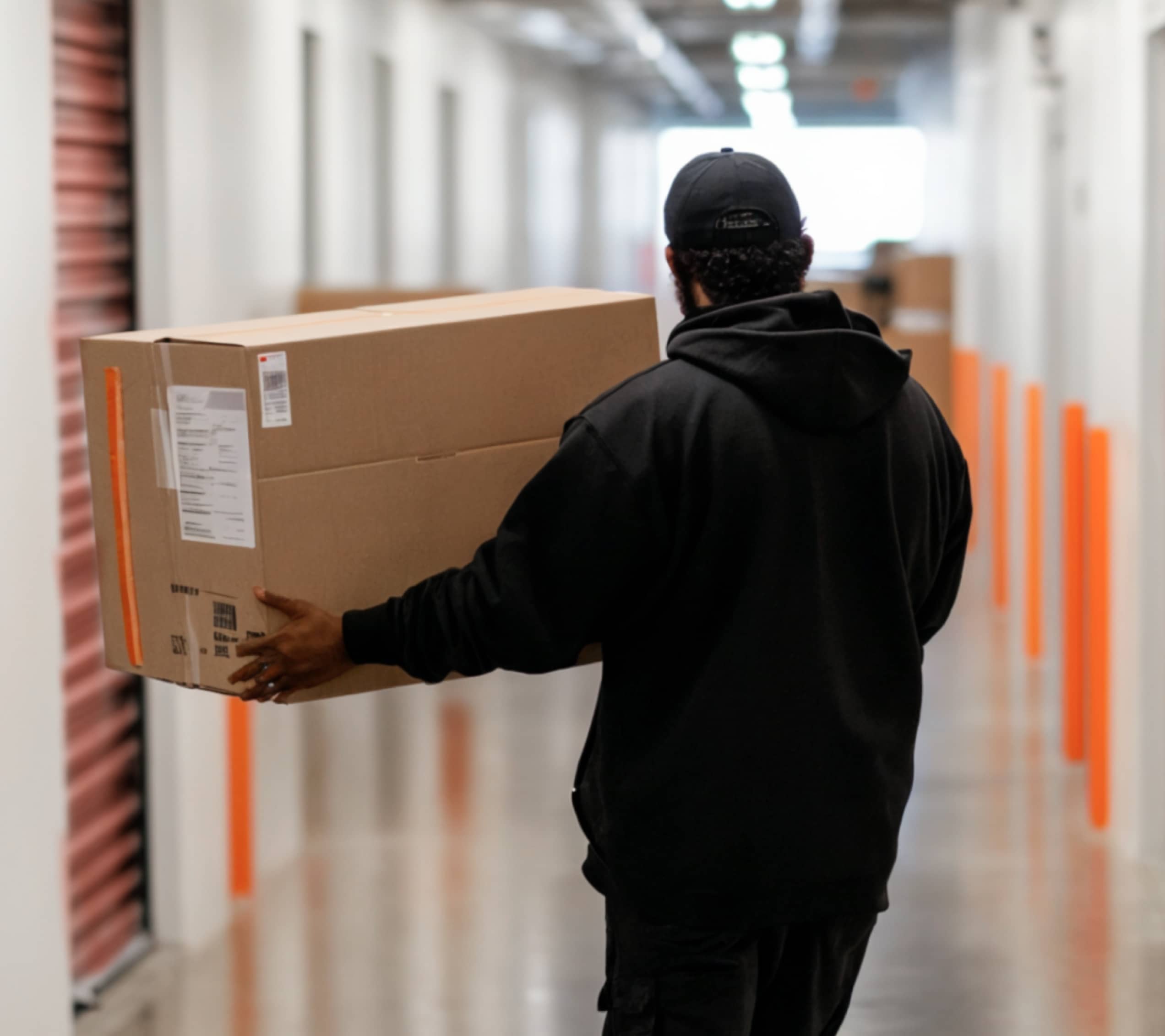 Man Dressed In Black Lifts A Box - SelfStorage X Webflow Template
