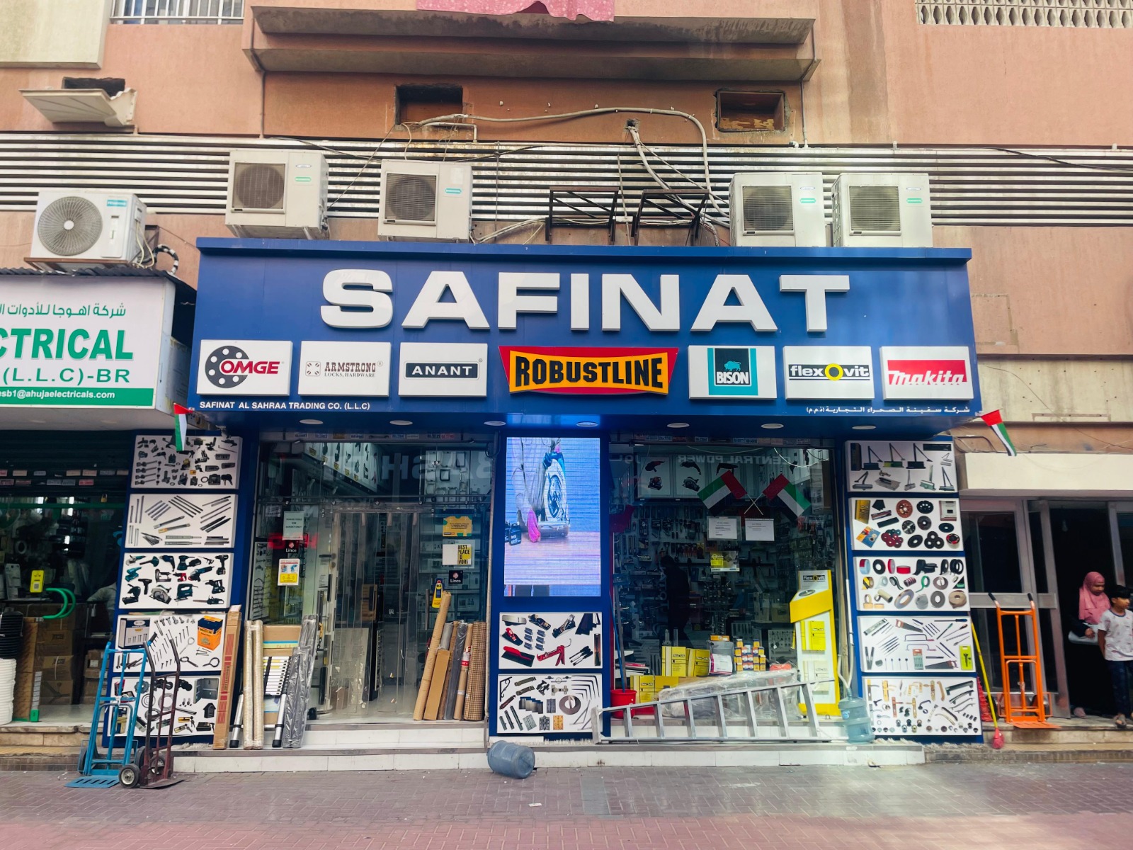 Front view of Safinat hardware store with signage displaying brand logos and tools on the exterior walls.
