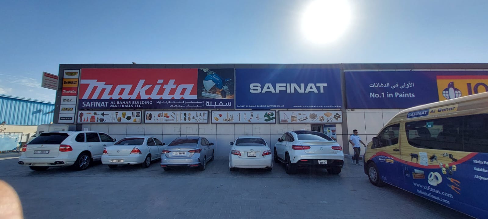 Exterior view of Safinat Al Bahar Building Materials showroom with Makita signage, parked cars, and a branded Safinat van.