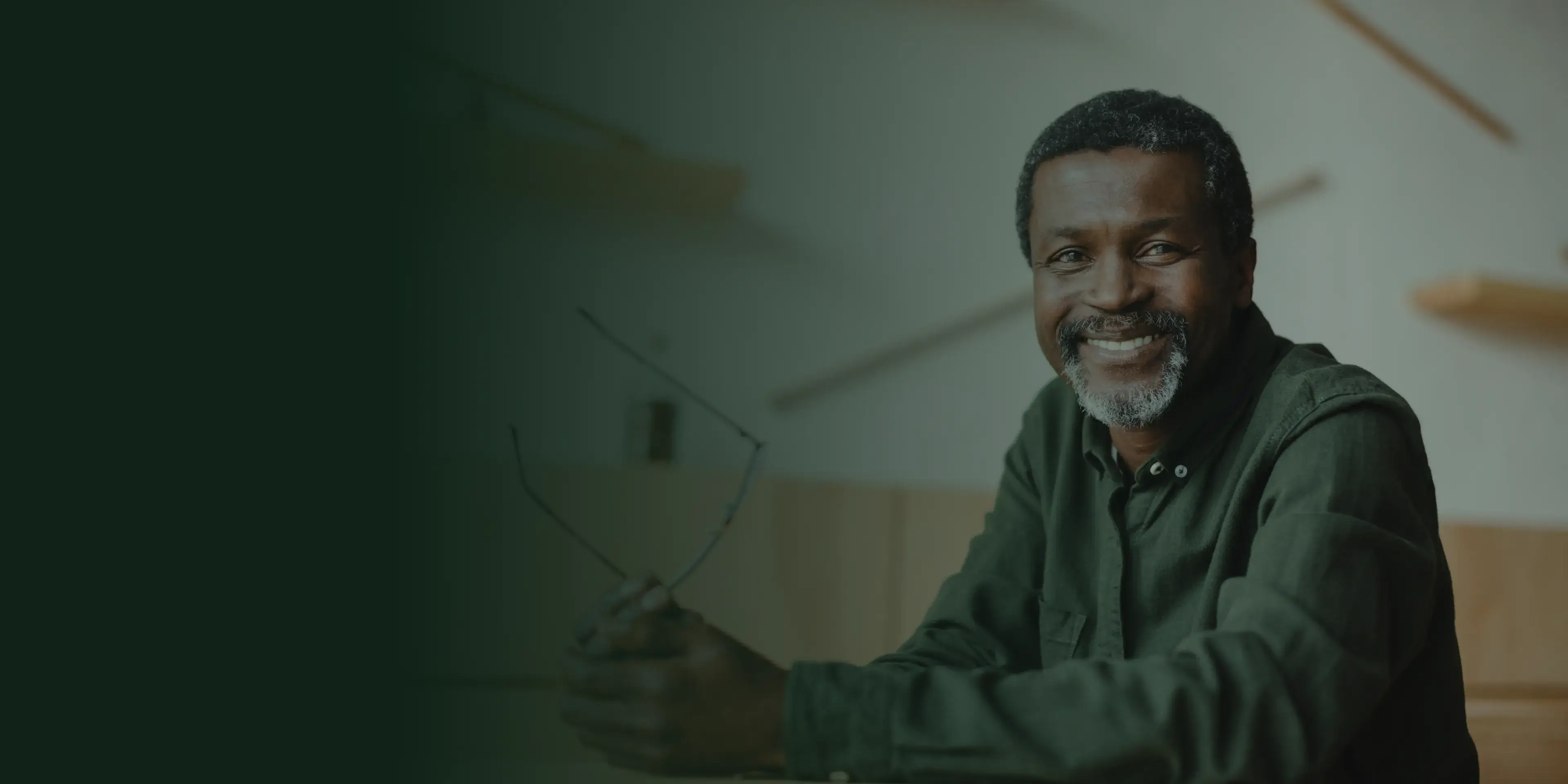 A woman with glasses smiles while standing outdoors in a yellow off-shoulder top.