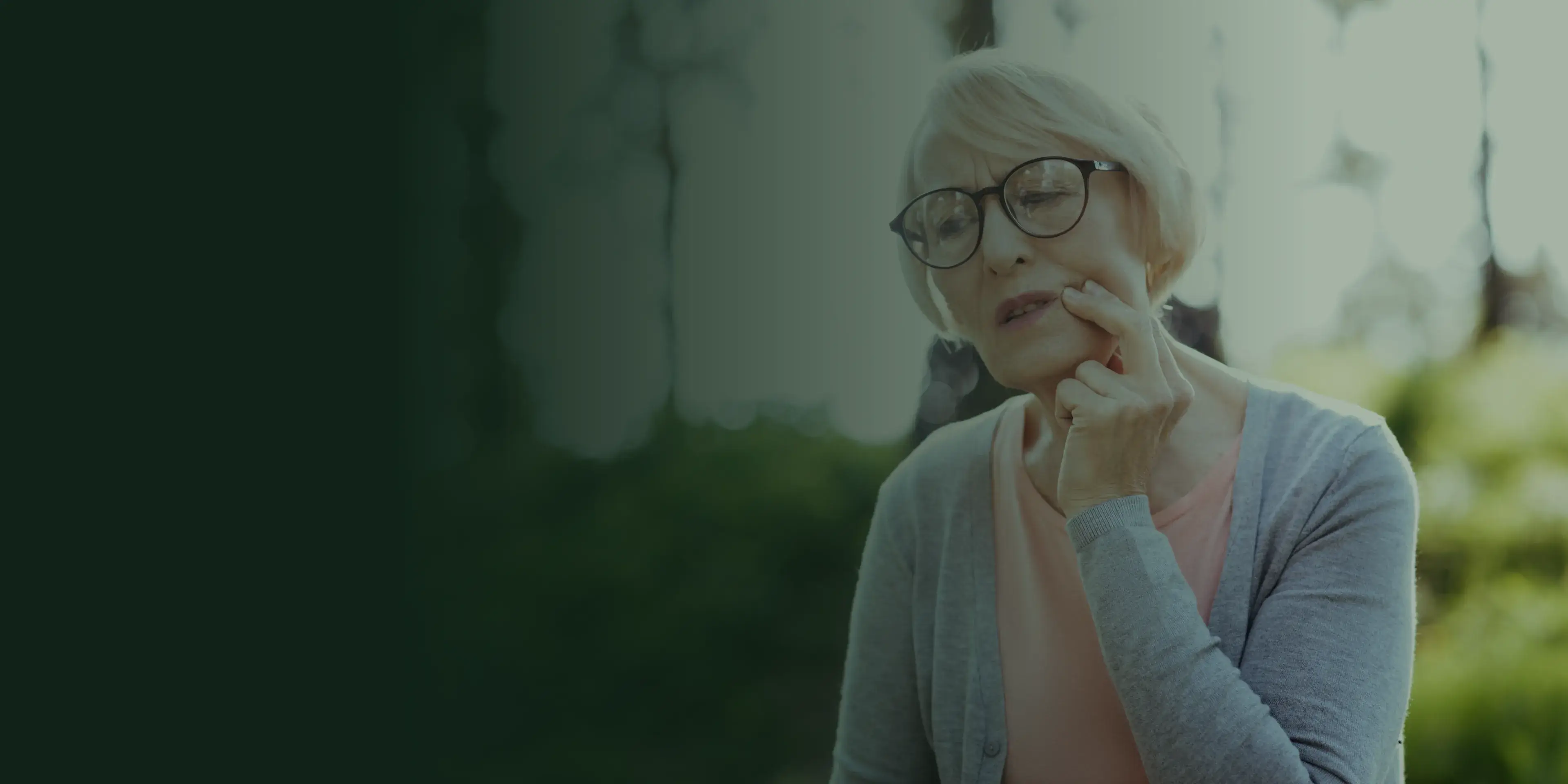 Woman smiling in a dental chair, talking with a dentist in a white coat.
