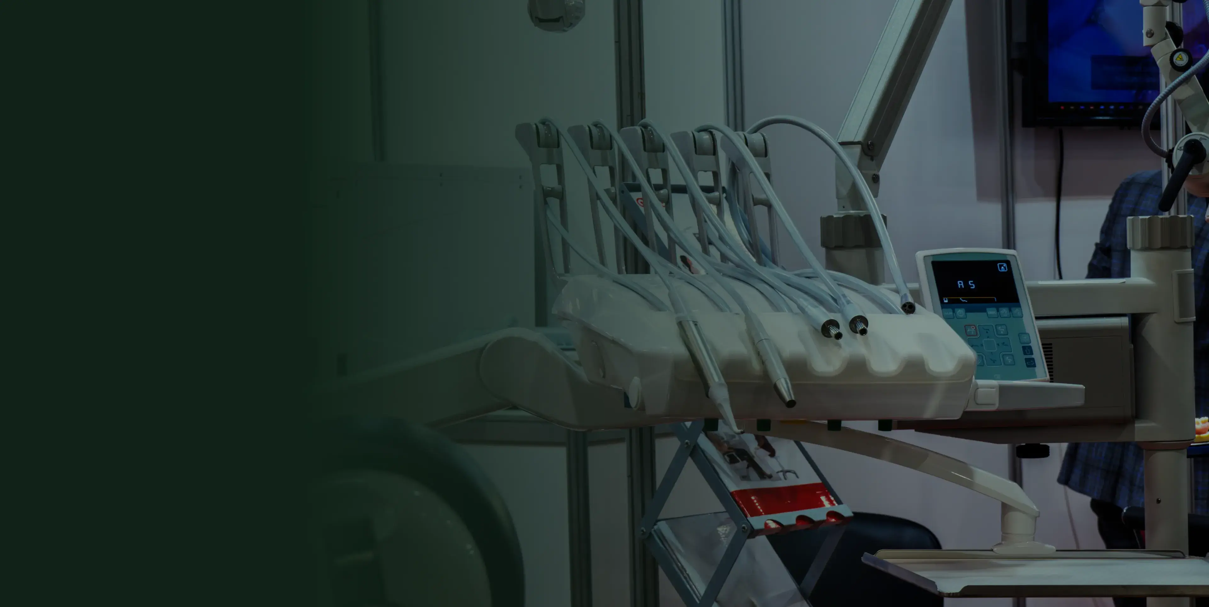 Dentist office with dental equipment and tools, including a control panel and various hoses.