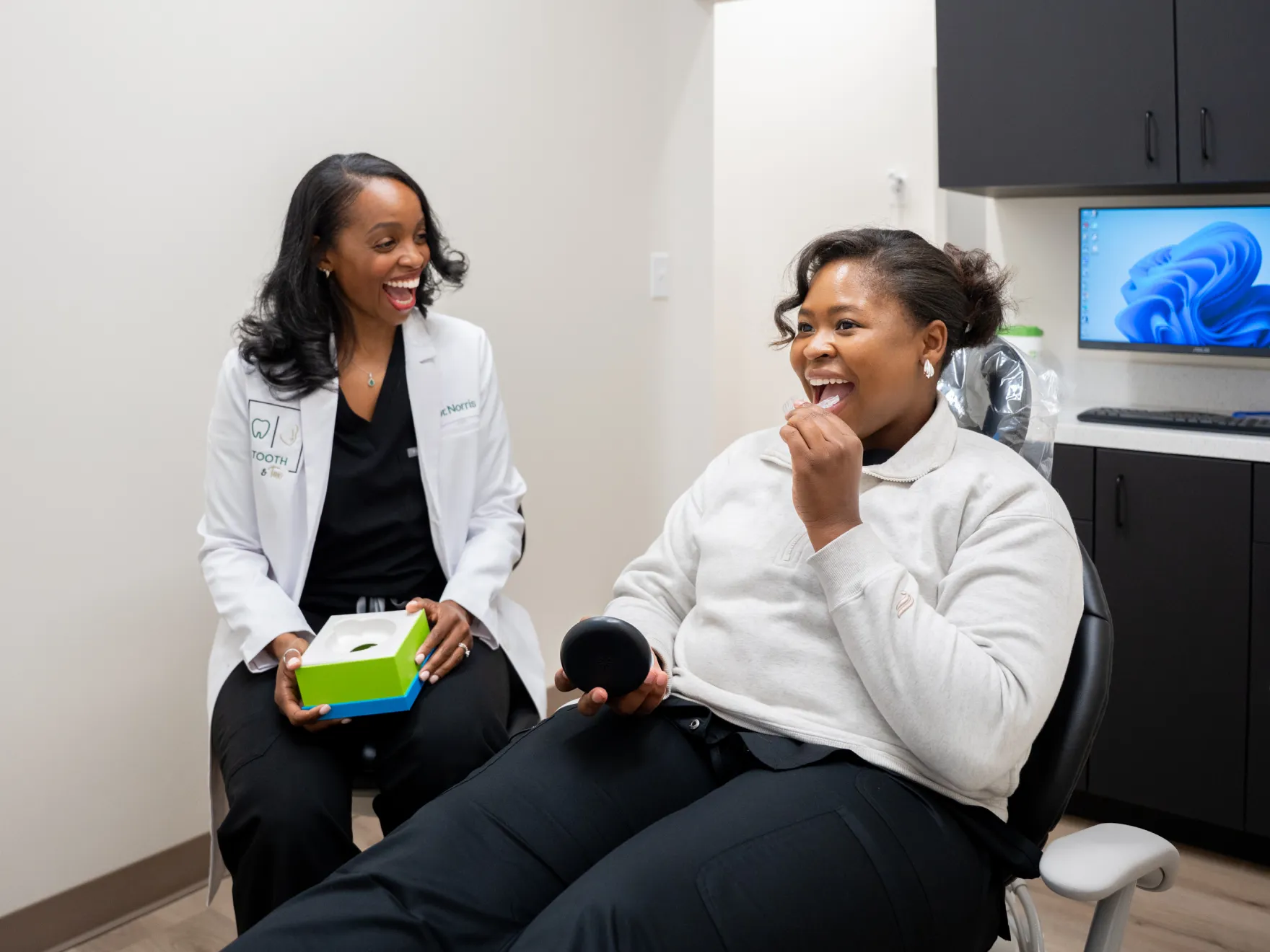 Dentist and patient smiling during a consultation in a dental office.