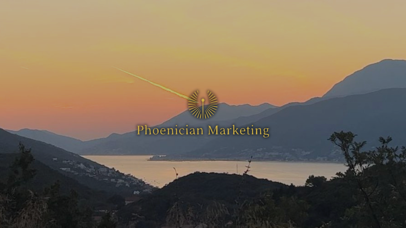 Phoenician Marketing logo over a tranquil mountain sunset, representing timeless branding and strategic digital marketing rooted in vision and growth