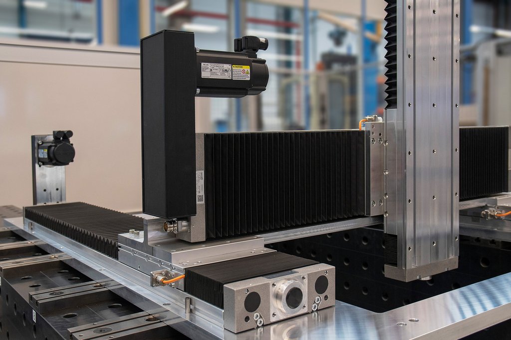Industriële precisie CNC-maschinelementen met lineaire geleiders en zwarte beschermhoezen.