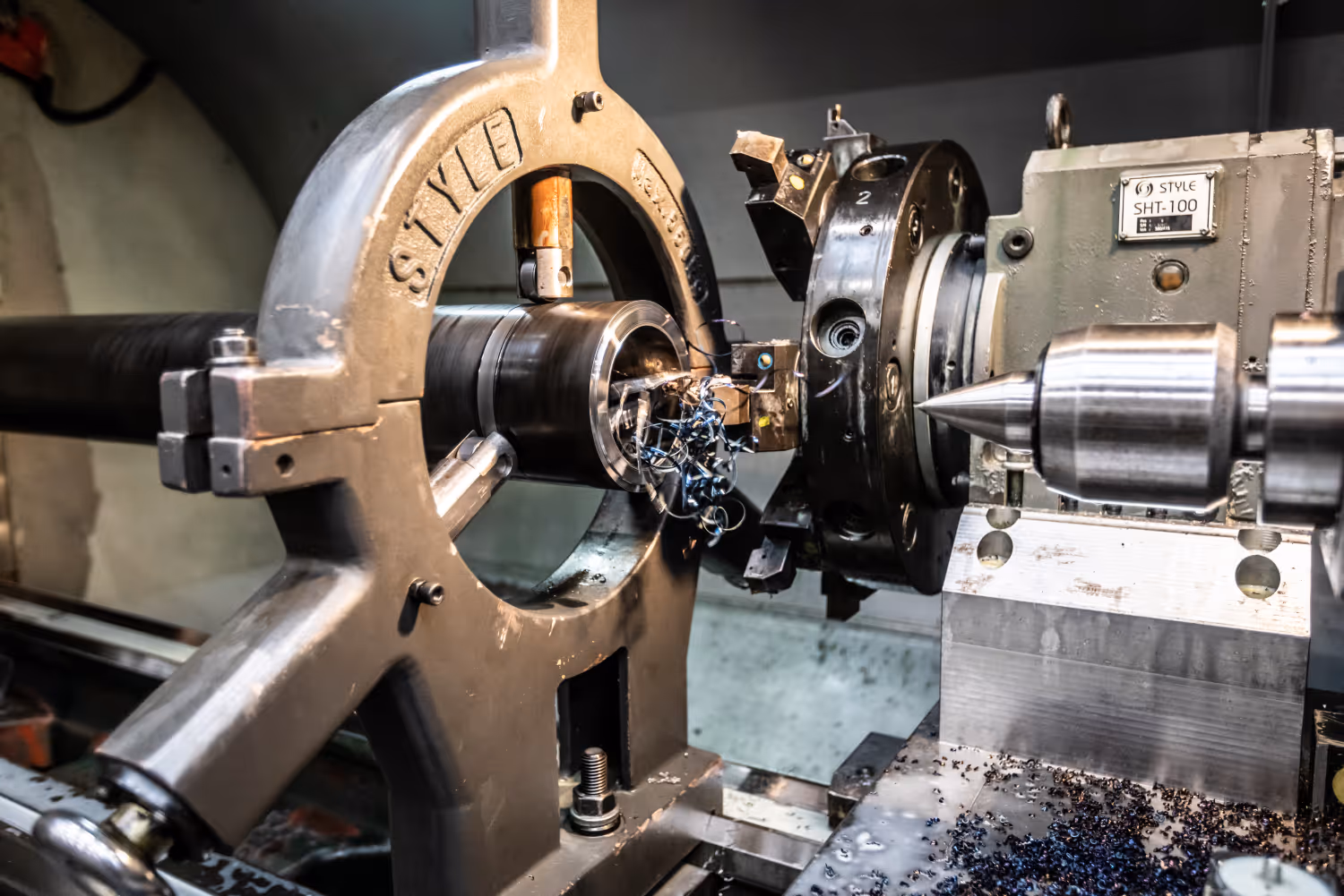 Metaaldraaibank die metalen cilinder bewerkt met spanen rondom het gereedschap.