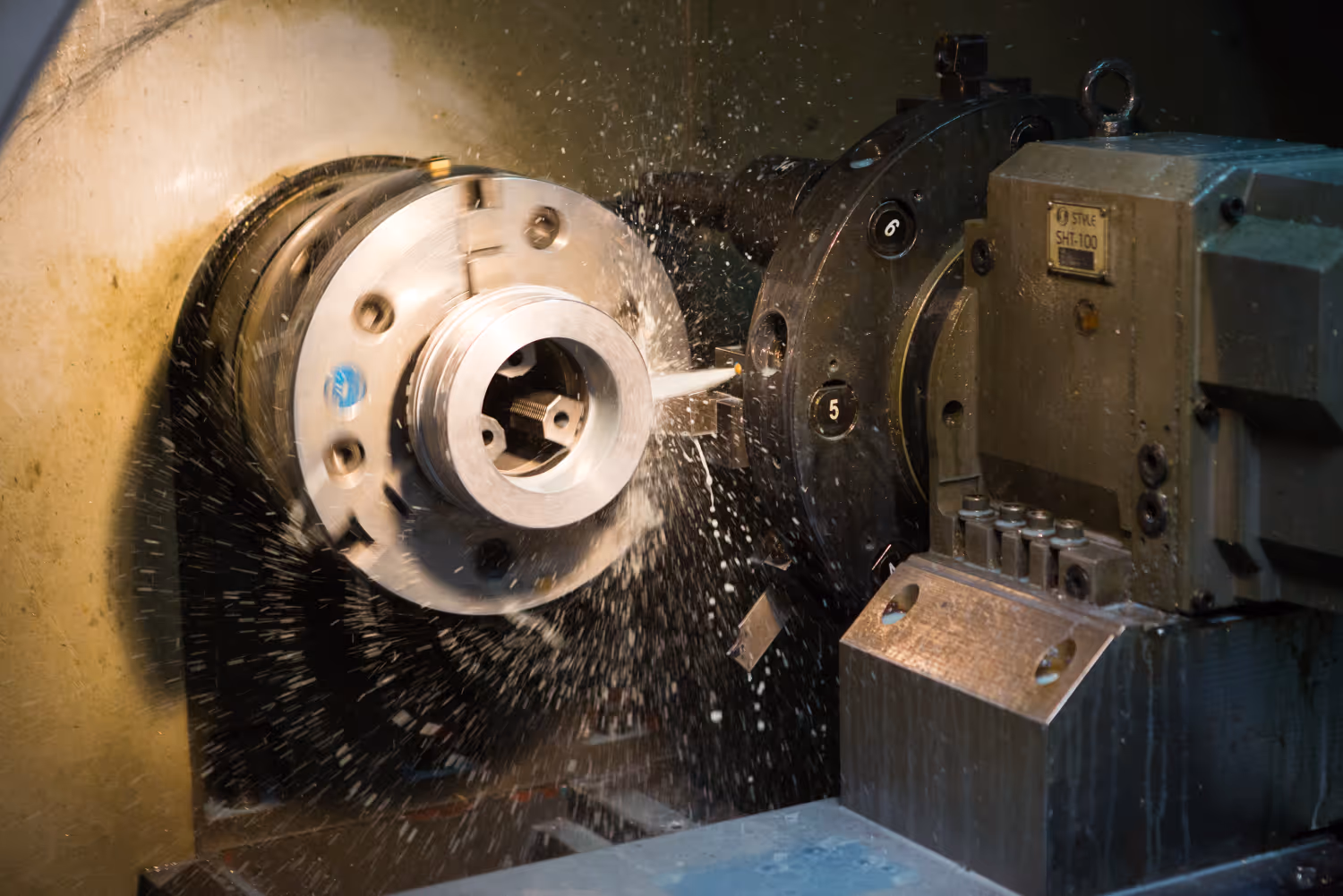 Draaimachine bewerkt metalen onderdeel met koelvloeistof die rond spuit tijdens bewerking.